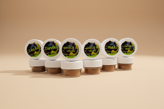 A set of small, labeled containers of various Huni Kuin Hapé blends positioned against a backdrop depicting a lush Amazonian rainforest landscape.