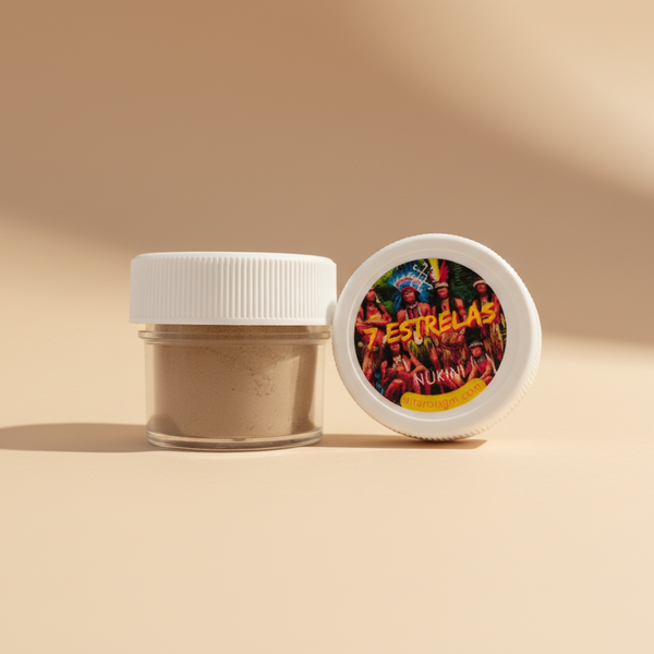 A small clear jar with a white lid containing a fine powder, next to a label featuring the text '7 Estrelas' on a background that appears to be a gathering of people.