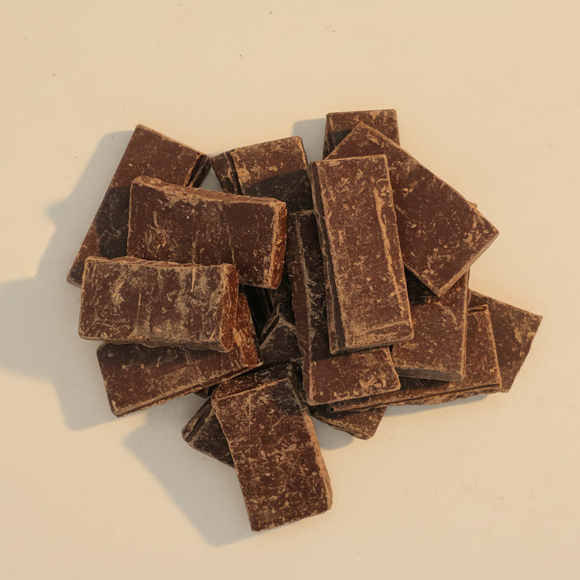 Stack of dark chocolate bars on a beige background