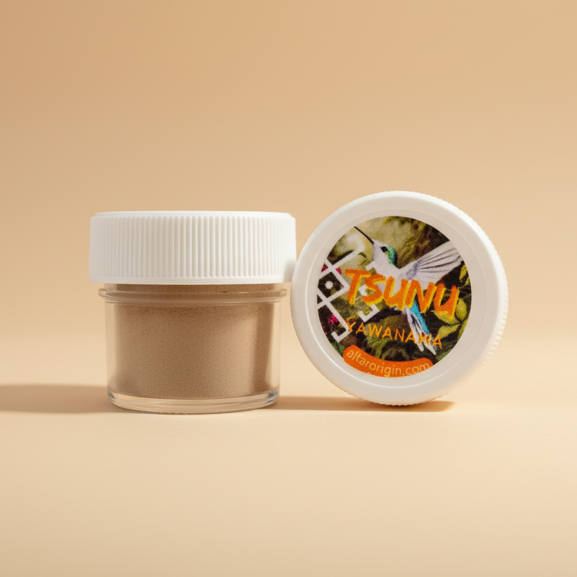 A small container of Yawanawa Tsunu Hapé powder next to its lid which has a label with the Yawanawa tribe's logo and a depiction of a plant or spirit being.
